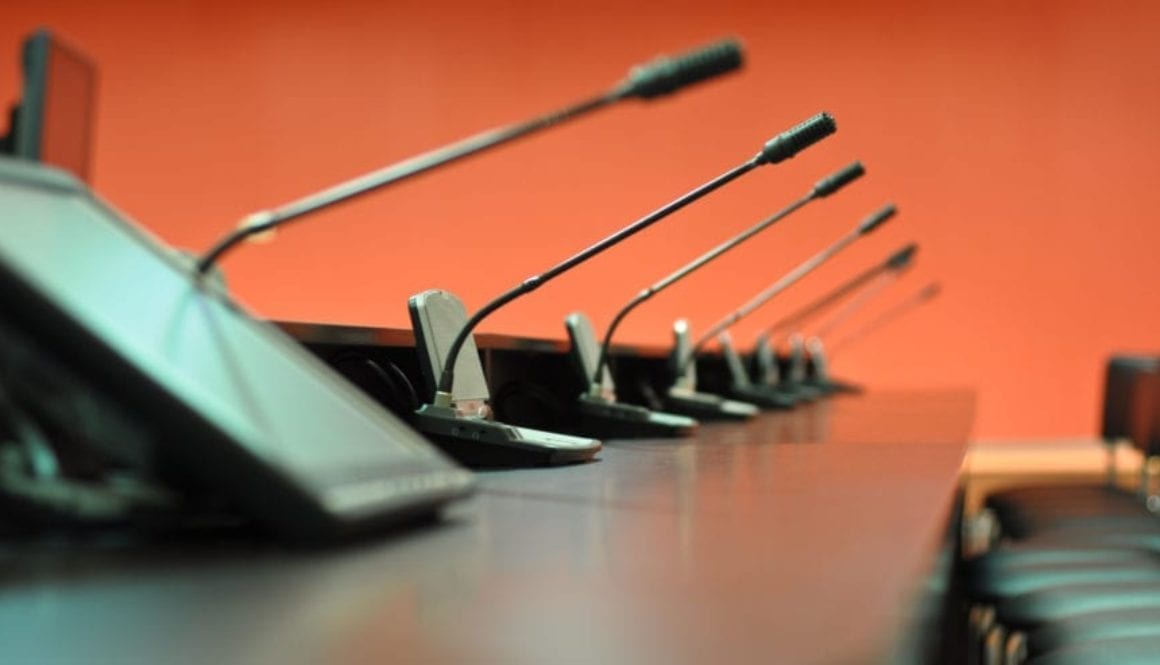 Conference table, microphones and office chairs close-up
