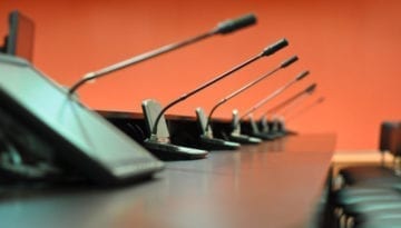 Conference table, microphones and office chairs close-up